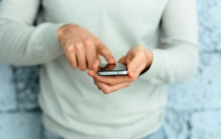 Closeup image of a male hand holding smartphone