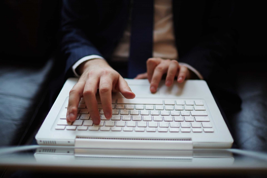 Male hands typing on laptop